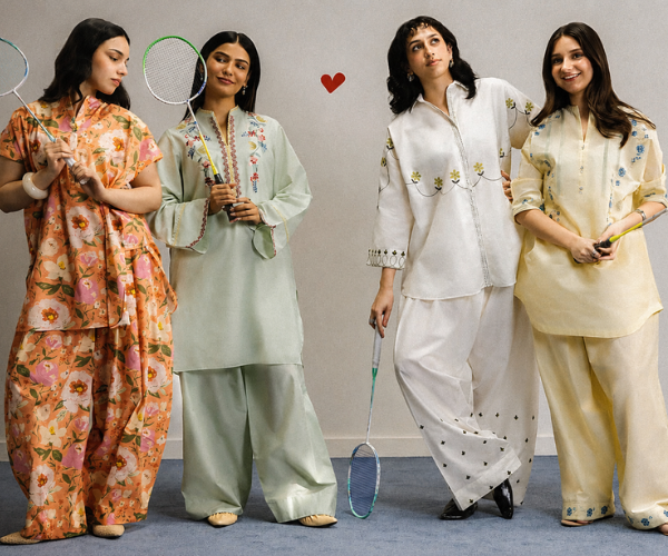 Four women modeling coordinated traditional lounge sets while holding badminton rackets in a studio setting